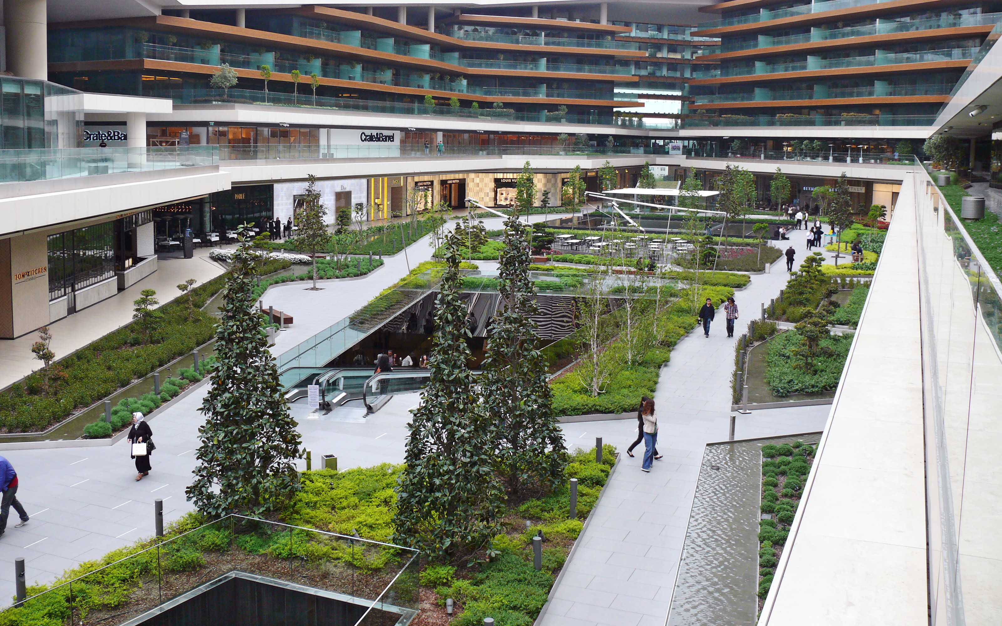 Vista de pájaro de la plaza principal con vegetación y escaleras mecánicas