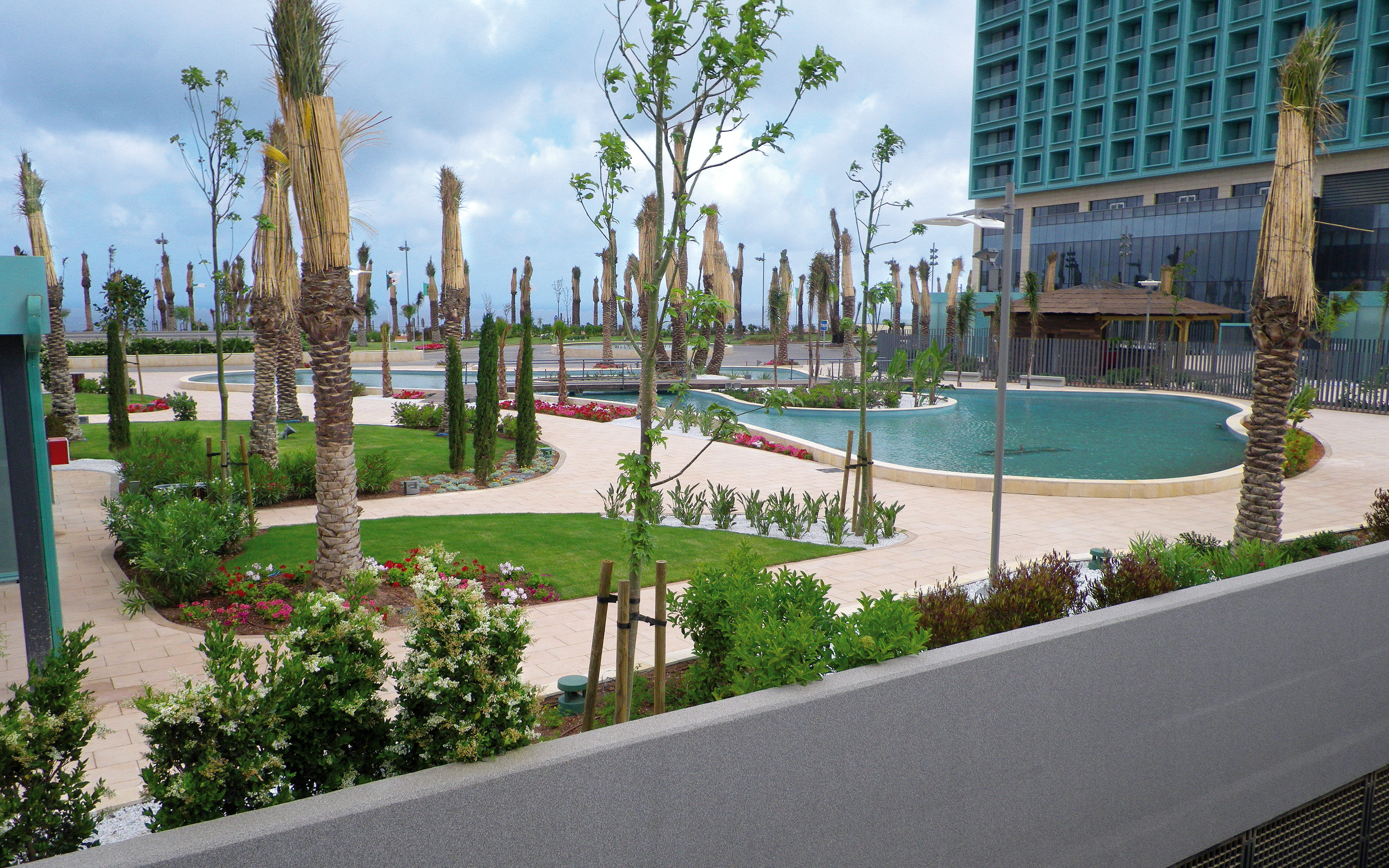 Un parque sobre un garaje subterranéo con piscinas y palmeras