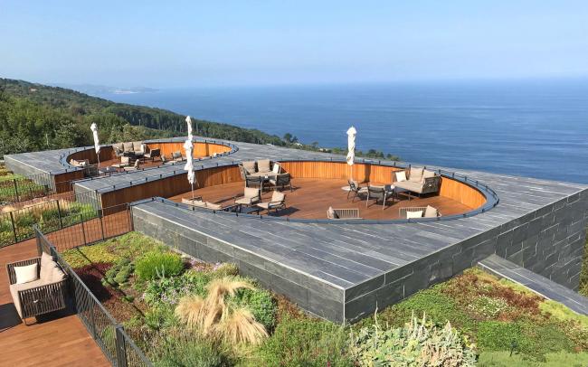 Cubierta jardín con zona de asientos de madera y vista al mar